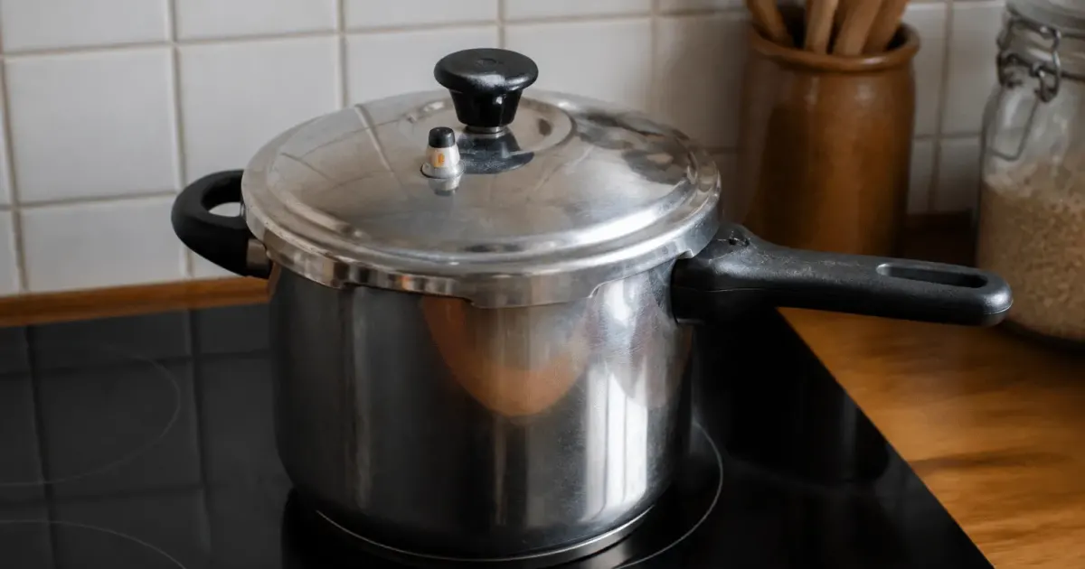 Chou-fleur entier dans cocotte-minute fermée sur plaque de cuisson