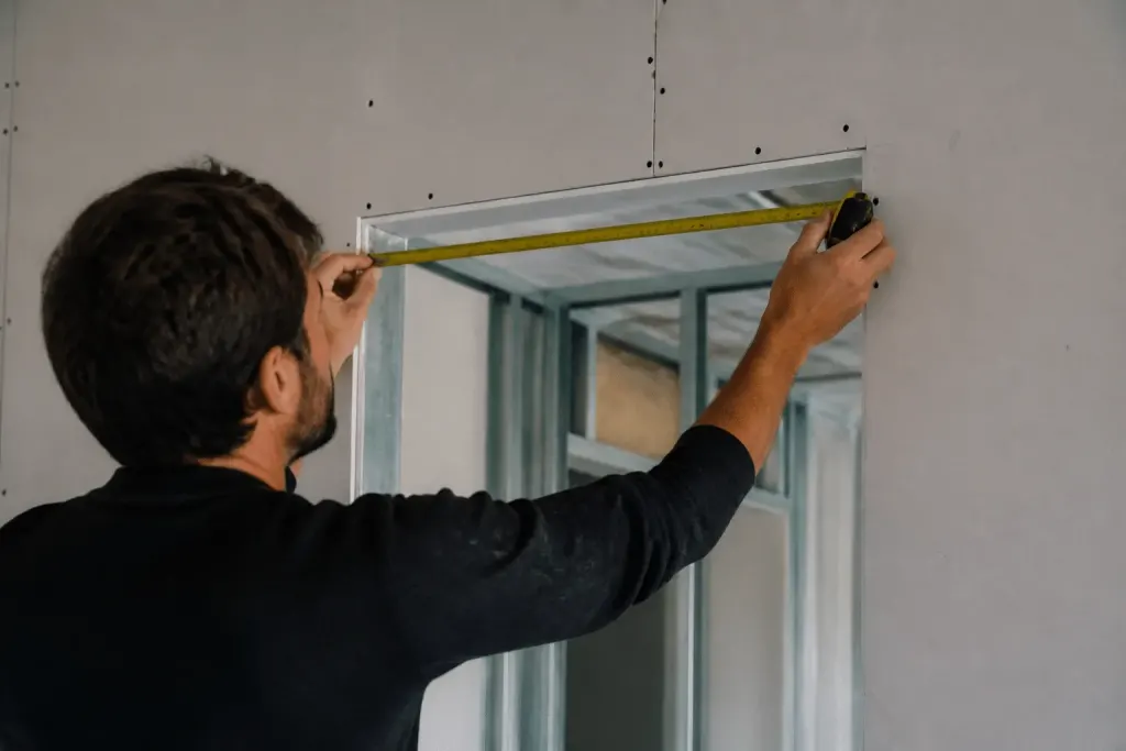 Metre ruban mesurant cadre porte sur cloison BA13