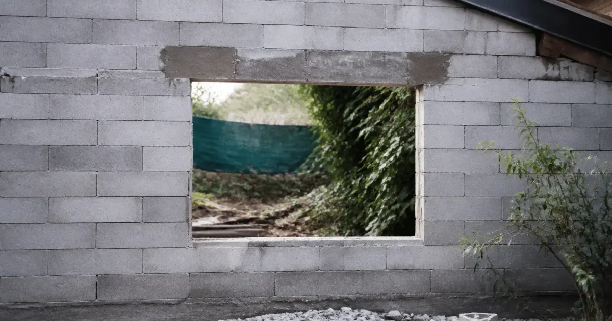 Mur en parpaing gris avec ouverture rectangulaire fraichement percée