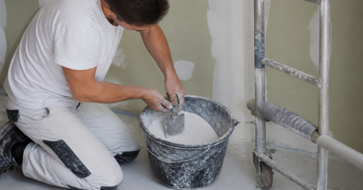 Homme melangeant poudre blanche dans seau avec spatule