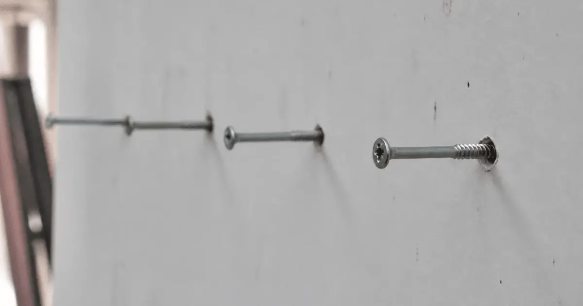 Vis metalliques alignees horizontalement enfoncees dans plaque plâtre