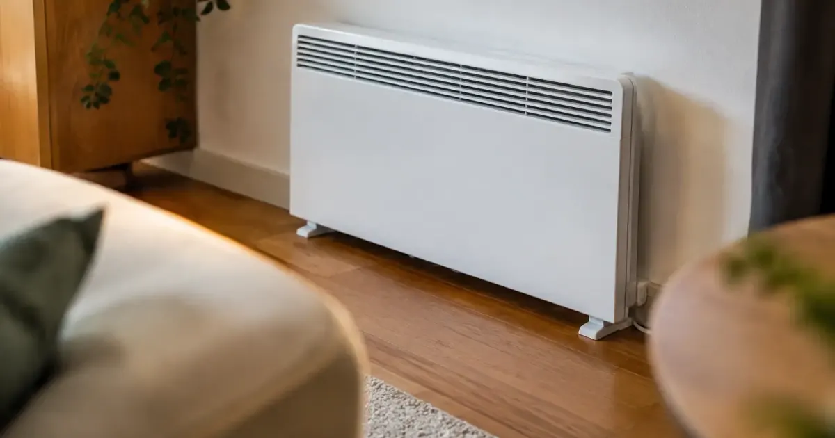 Convecteur electrique au sol contre un mur blanc