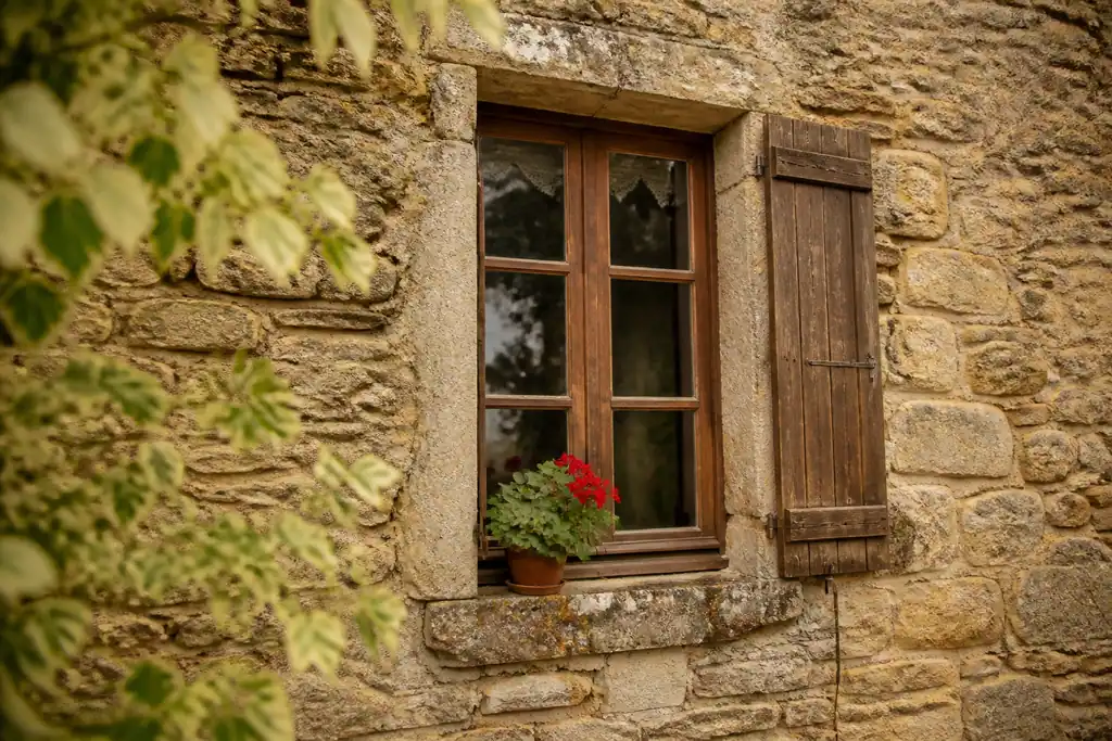 Facade ancienne en pierre avec fenetre en bois