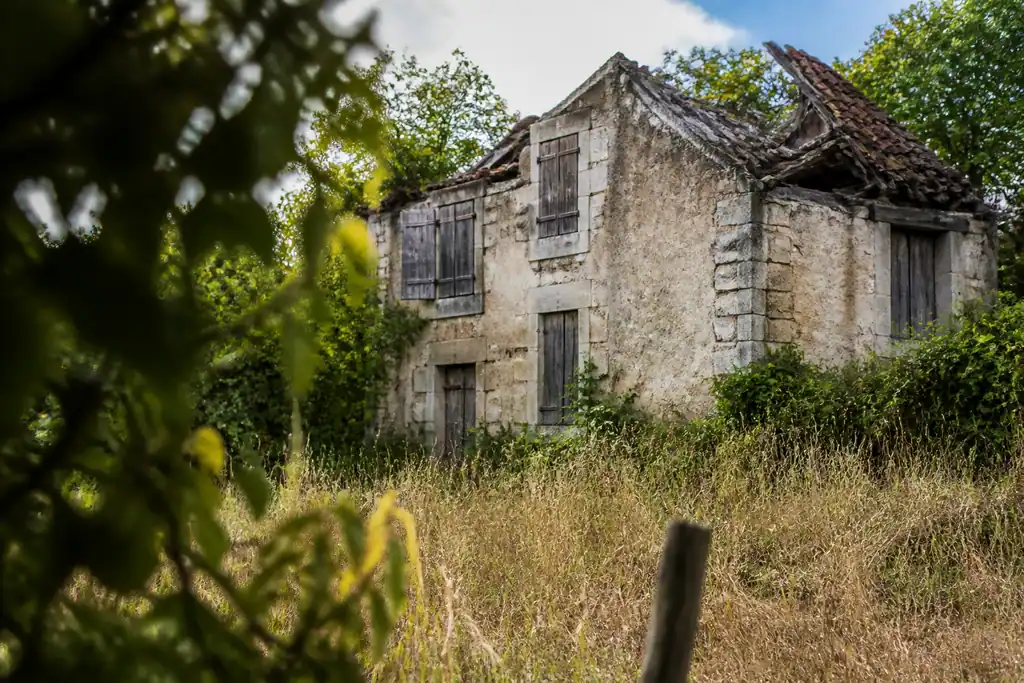 Maison abandonnee aux volets clos et toiture effondree