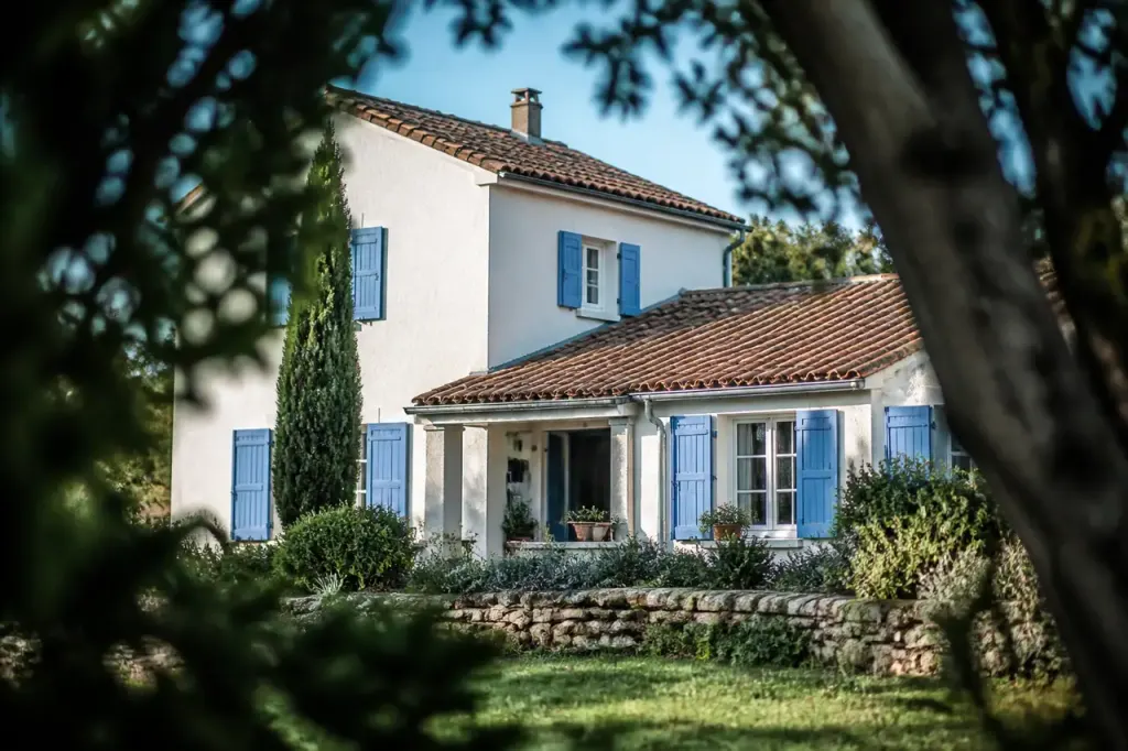 Maison familiale aux tuiles rouges et volets bleus