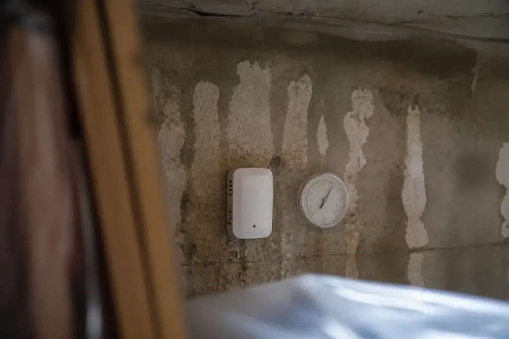 Mur humide avec petit appareil blanc et hygrometre