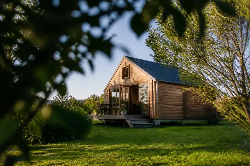 Petite maison en bois posee sur une pelouse verte